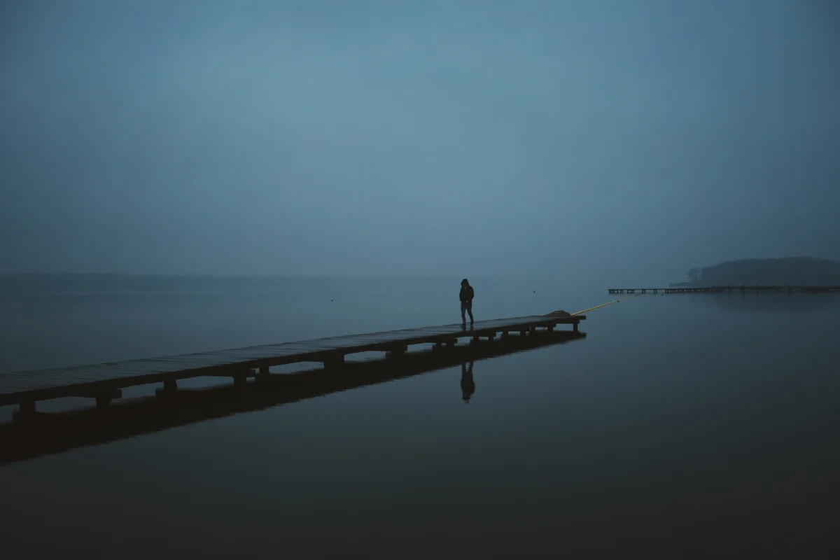 Fotografia krajobrazowa — samotna postać na pomoście nad jeziorem we mgle, Jakub Klisowski JVISION