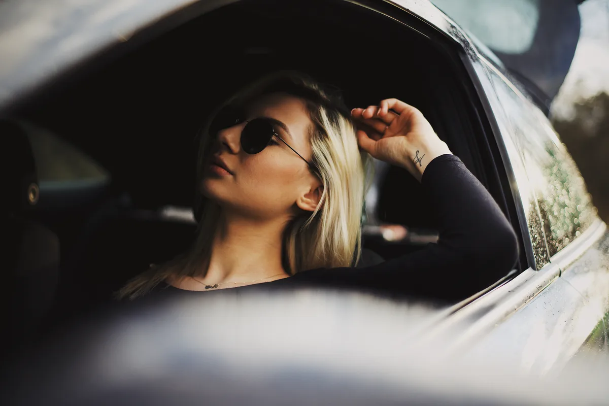 Fotografia portretowa — kobieta w okularach opierająca się o okno auta, Jakub Klisowski JVISION